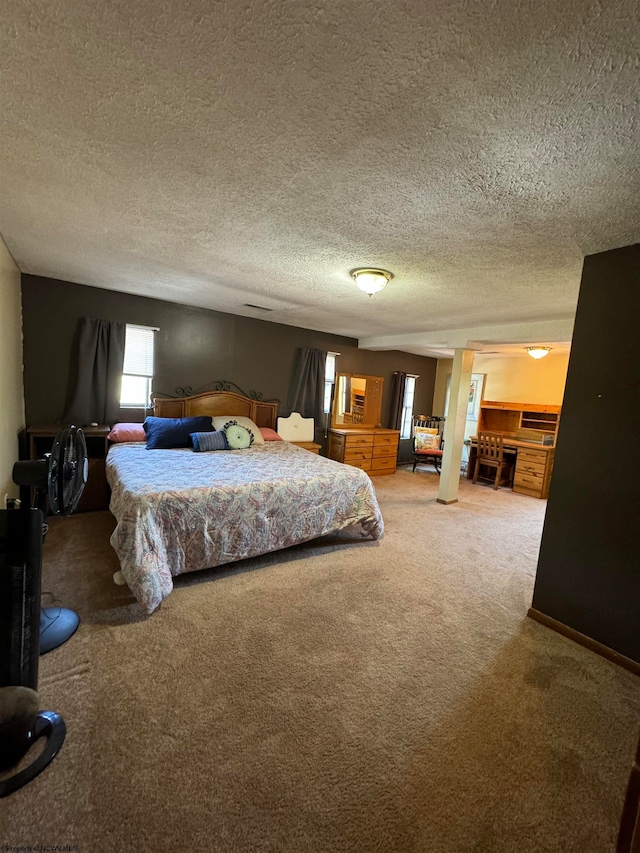 bedroom with a textured ceiling, carpet flooring, and baseboards