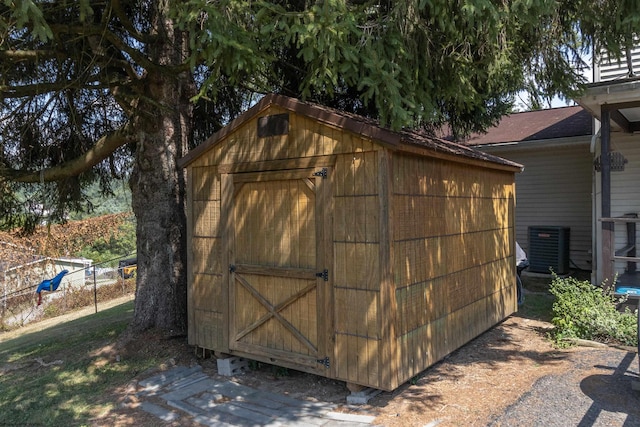 view of shed with fence and central air condition unit