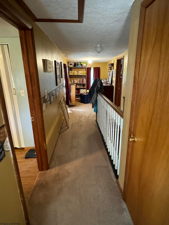 corridor featuring a textured ceiling and wood finished floors