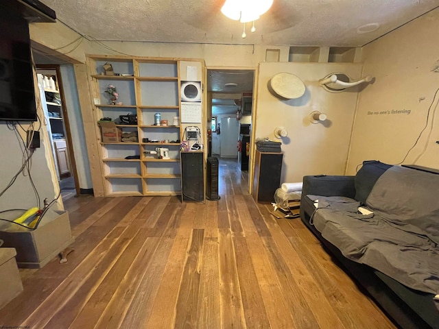 living room with hardwood / wood-style floors, ceiling fan, and a textured ceiling