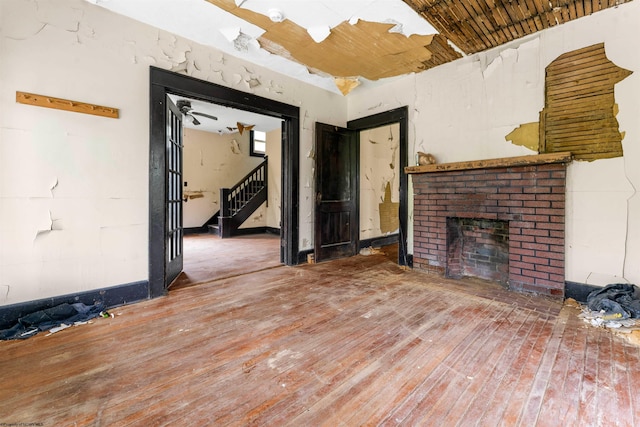 unfurnished living room with hardwood / wood-style flooring, a brick fireplace, ceiling fan, and wooden ceiling