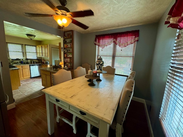 dining space featuring light hardwood / wood-style floors, ceiling fan, and a textured ceiling