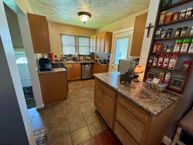 kitchen with a healthy amount of sunlight, tile floors, dishwasher, and a textured ceiling