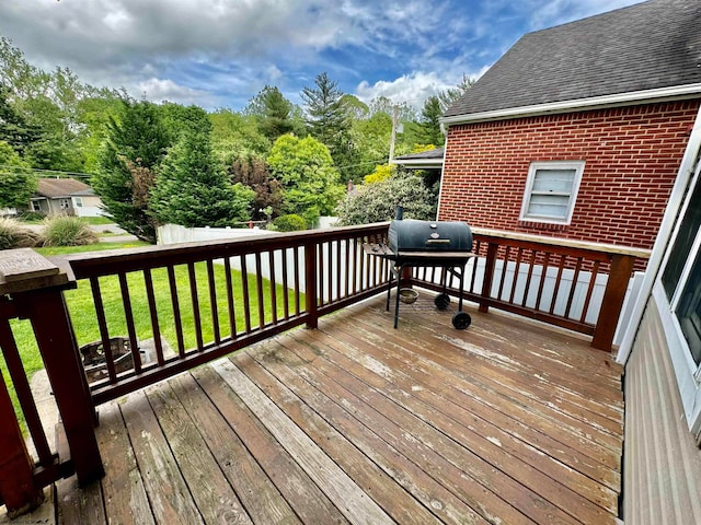 wooden deck with a grill and a lawn