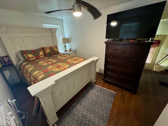 bedroom with dark hardwood / wood-style flooring and ceiling fan