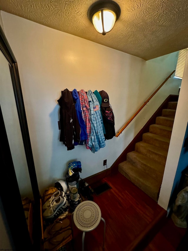 stairs with a textured ceiling