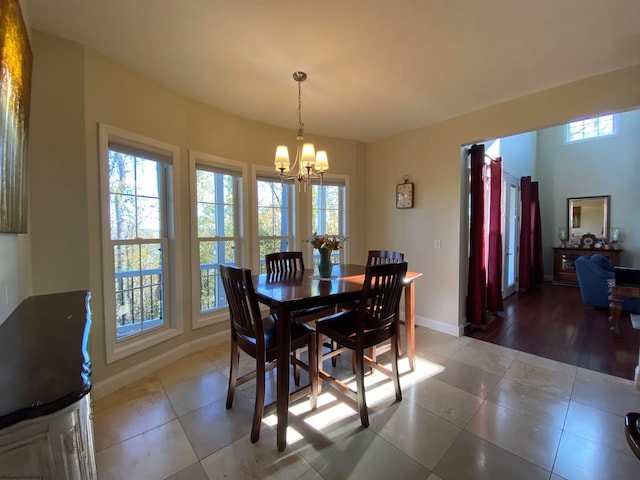 dining space with a notable chandelier, a healthy amount of sunlight, and tile floors