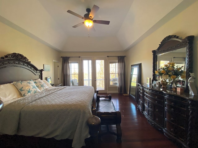 bedroom featuring access to outside, french doors, dark wood-type flooring, a tray ceiling, and ceiling fan