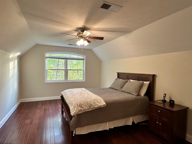 bedroom featuring ceiling fan, dark hardwood / wood-style flooring, lofted ceiling, and a textured ceiling