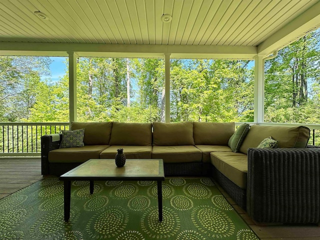 sunroom / solarium featuring a healthy amount of sunlight and wooden ceiling