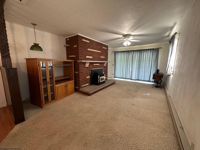 living room with ceiling fan, carpet, a wood stove, and a textured ceiling