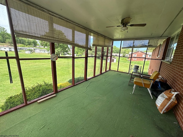 unfurnished sunroom featuring ceiling fan