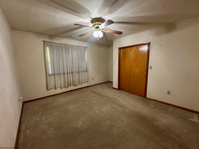 unfurnished bedroom with light carpet, ornamental molding, and ceiling fan