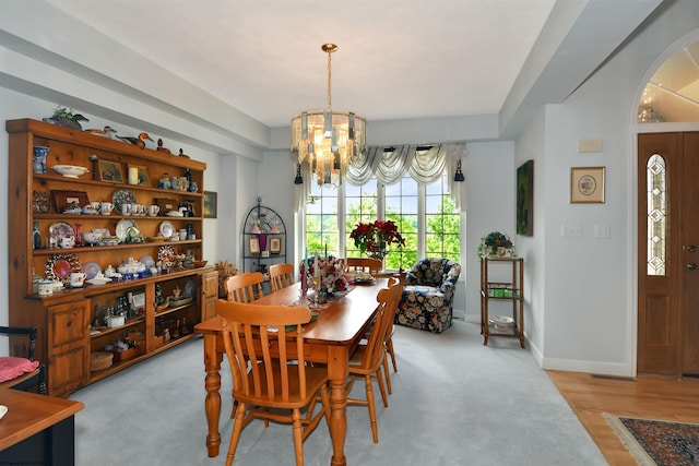 dining space with a notable chandelier and light wood-type flooring