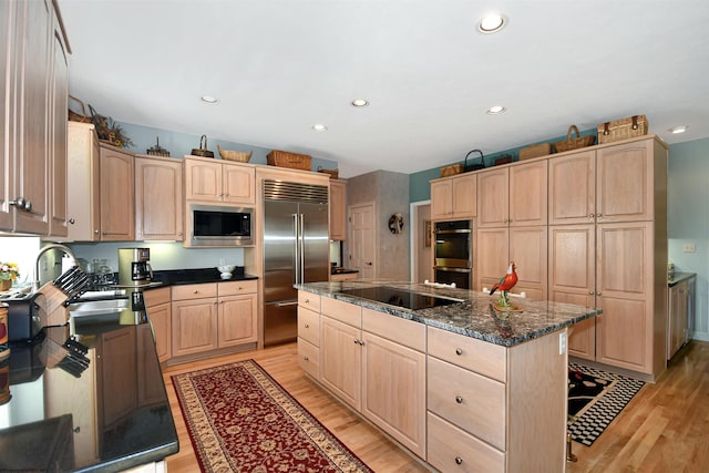 kitchen with a center island, built in appliances, light hardwood / wood-style flooring, light brown cabinetry, and sink