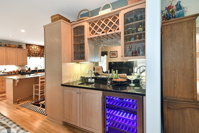 bar with a healthy amount of sunlight, light wood-type flooring, sink, and beverage cooler