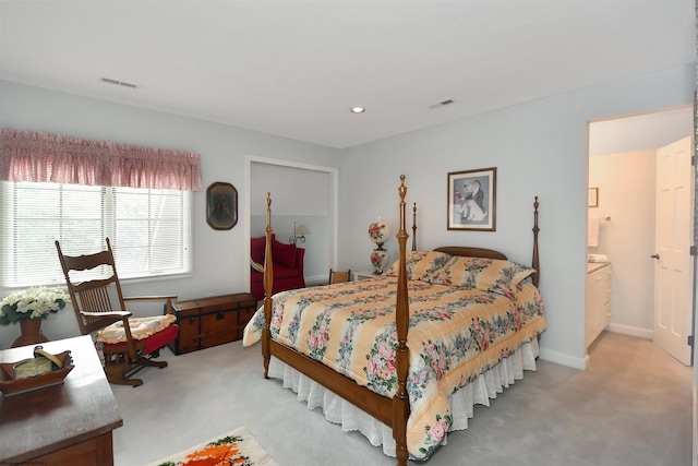 bedroom with ensuite bath and carpet flooring