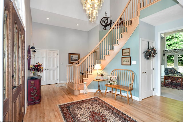 entrance foyer with hardwood / wood-style floors, a notable chandelier, and a high ceiling