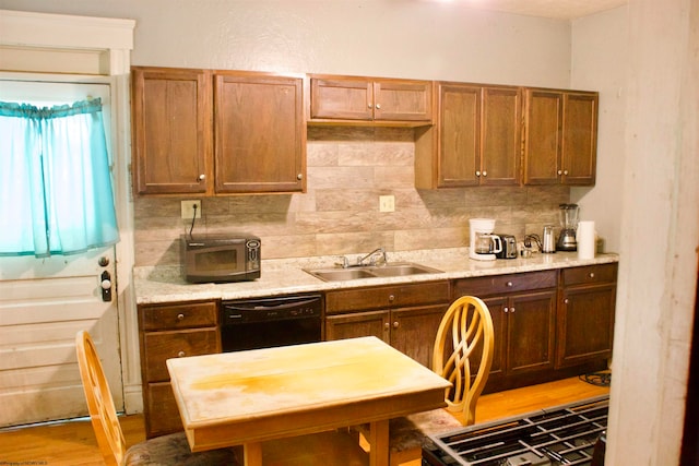 kitchen featuring tasteful backsplash, sink, black appliances, and light wood-type flooring