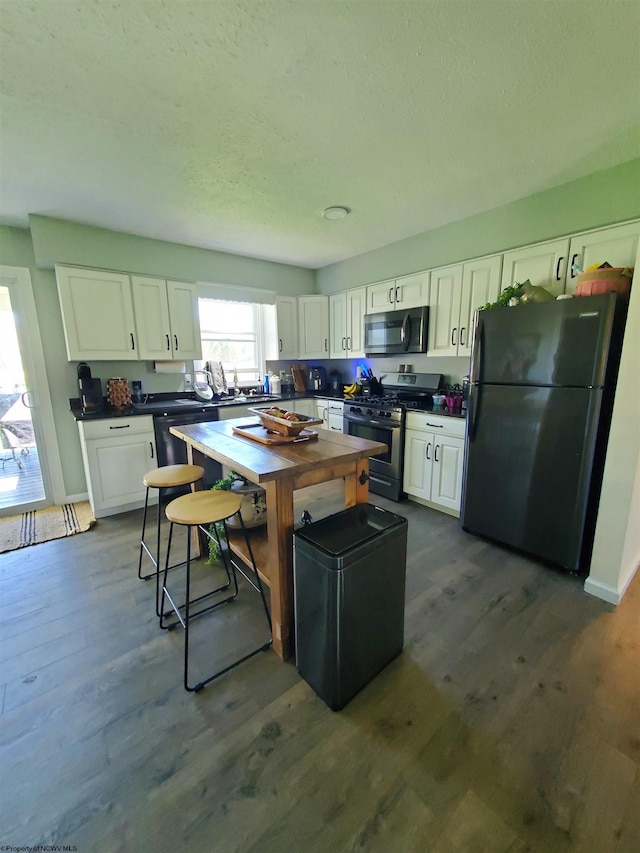 kitchen featuring white cabinets, dark wood-type flooring, and black appliances