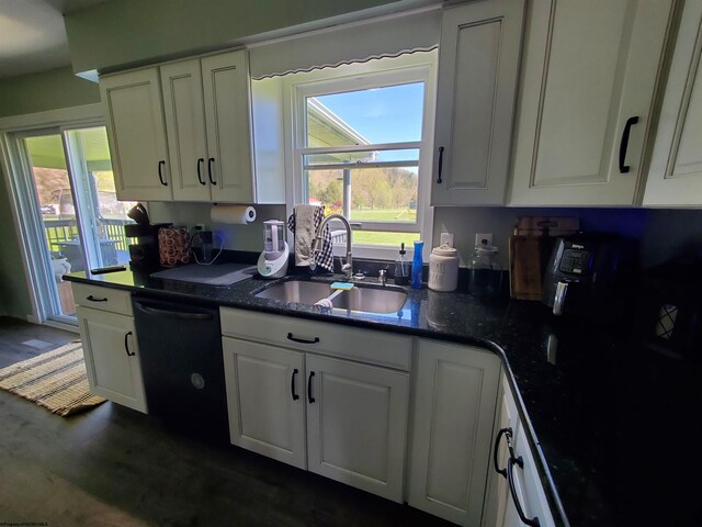 kitchen featuring dishwasher, white cabinets, dark stone counters, and sink