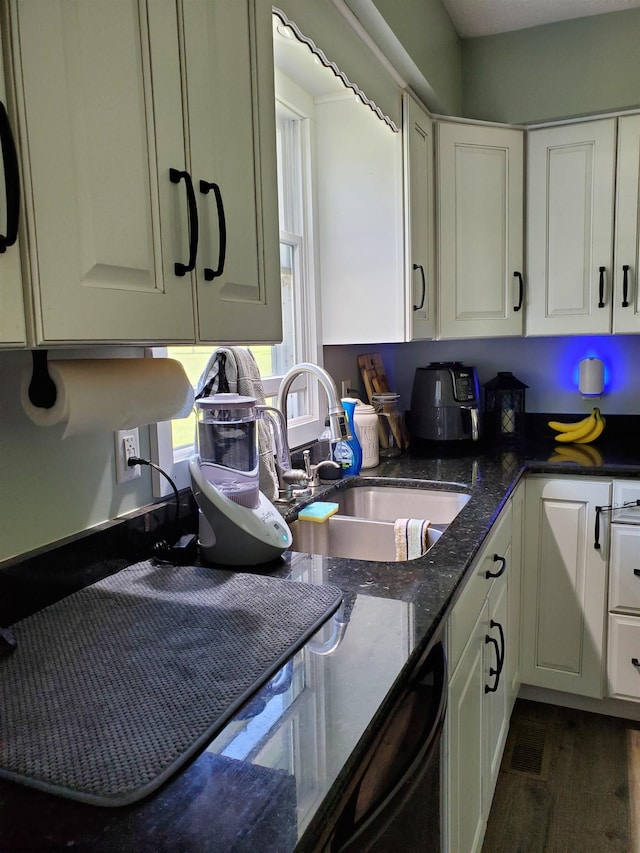 kitchen with dark stone counters, sink, dishwasher, dark hardwood / wood-style floors, and white cabinetry