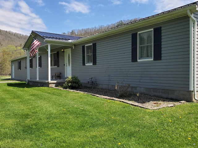 view of side of home with a lawn and covered porch