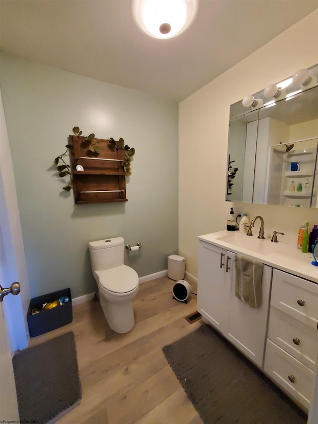 bathroom featuring vanity, wood-type flooring, and toilet