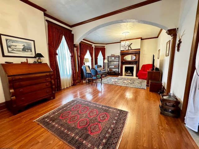 foyer entrance with ornamental molding, wood-type flooring, and an inviting chandelier