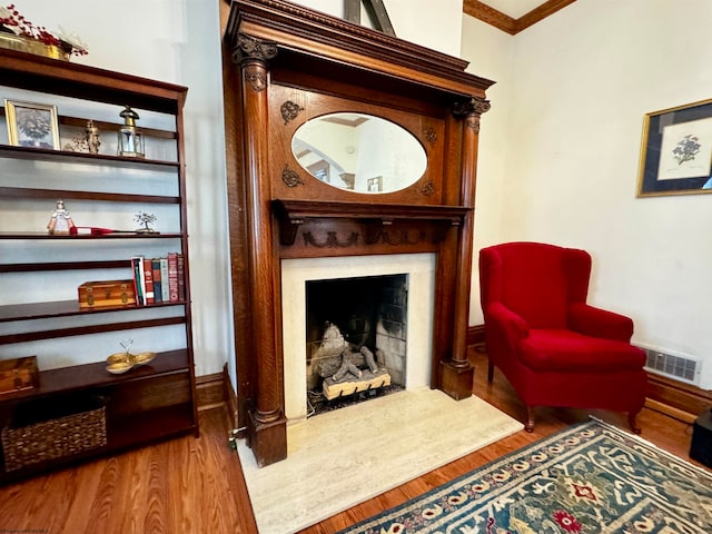 sitting room featuring wood-type flooring and ornamental molding