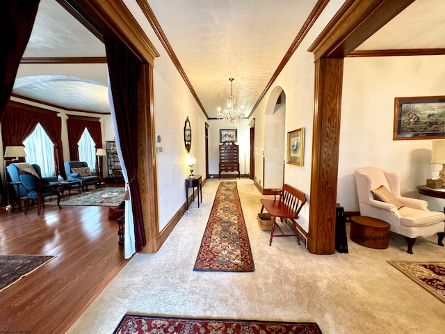 hallway with an inviting chandelier, hardwood / wood-style flooring, and crown molding