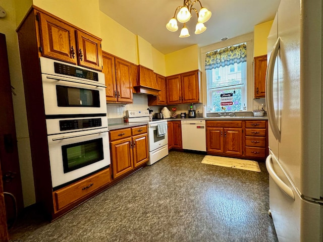 kitchen featuring white appliances, a notable chandelier, sink, dark tile floors, and custom exhaust hood