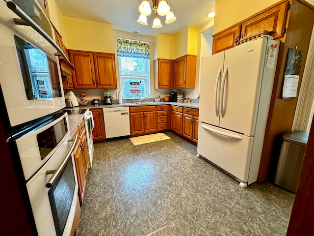 kitchen with white appliances, a chandelier, and dark tile floors