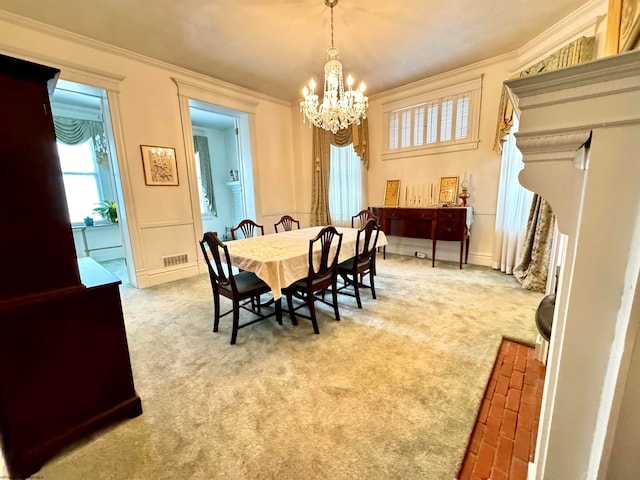 carpeted dining space with crown molding and an inviting chandelier