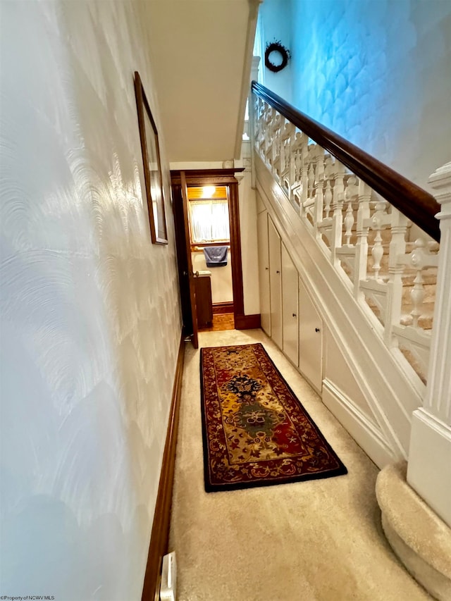 hall with light colored carpet