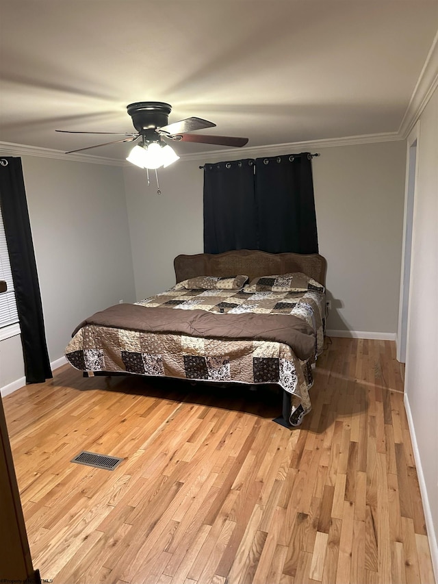 bedroom with ceiling fan, light hardwood / wood-style floors, and crown molding