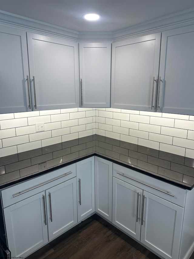 kitchen with backsplash, white cabinetry, and dark hardwood / wood-style flooring