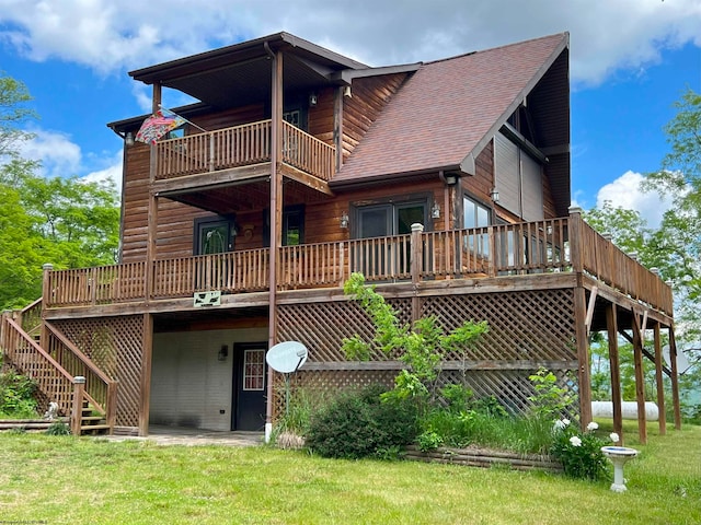 back of property with a lawn and a balcony