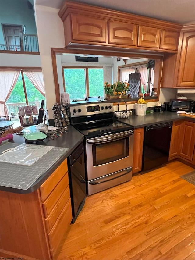 kitchen featuring dishwasher, light wood-type flooring, electric stove, and plenty of natural light