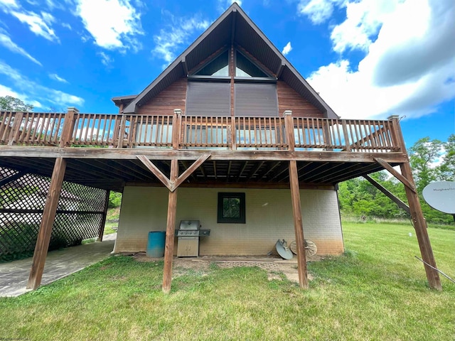 rear view of house featuring a yard and a wooden deck