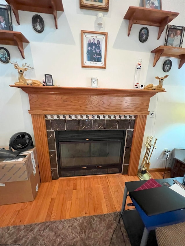 interior details with a tile fireplace and hardwood / wood-style floors