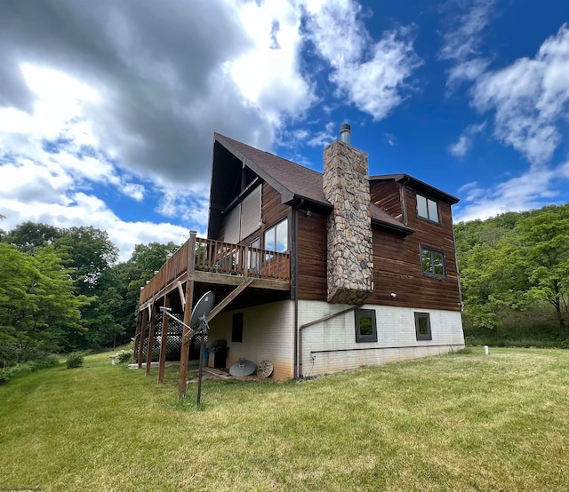 back of property with a deck and a lawn