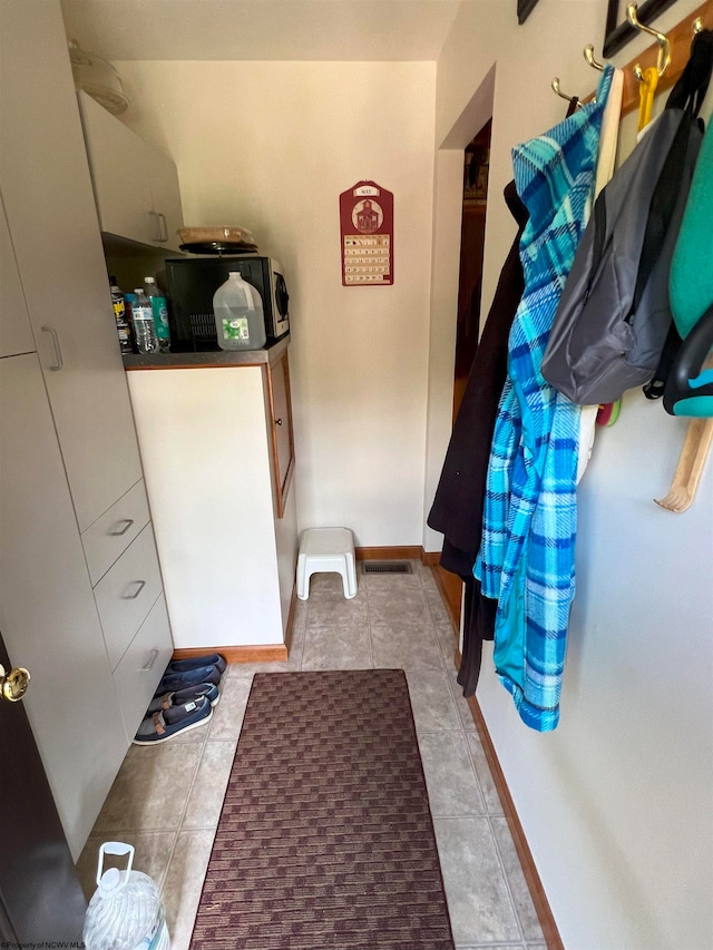 laundry area with light tile patterned floors