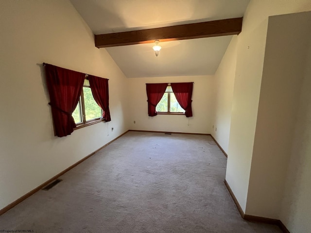 spare room featuring vaulted ceiling with beams and light colored carpet