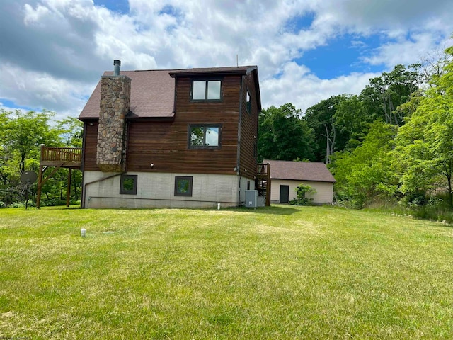 back of property with central air condition unit, a wooden deck, and a yard