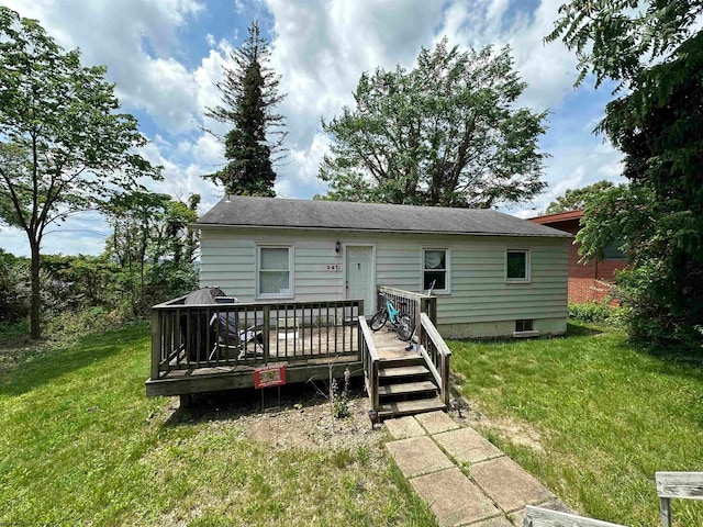 view of front of home with a deck and a front lawn