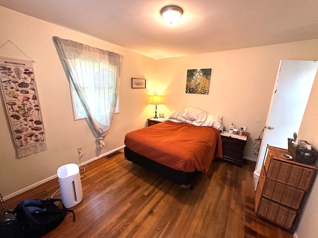 bedroom with dark hardwood / wood-style floors