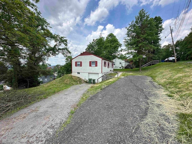 view of front of house featuring aphalt driveway and a front lawn