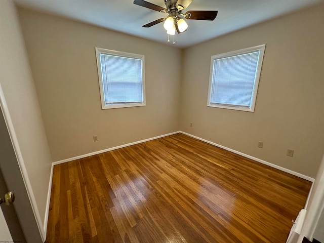 unfurnished room featuring ceiling fan, baseboards, and wood finished floors