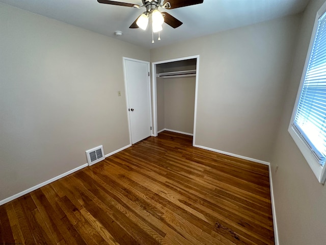 unfurnished bedroom with ceiling fan, hardwood / wood-style flooring, and a closet